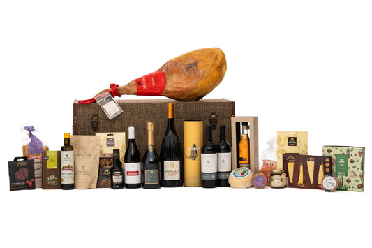 Um Cabaz de Natal com uma seleção requintada de vinhos de excelência, champagne, Porto, aguardente e iguarias tradicionais portuguesas. Destaca-se o presunto  reserva, queijos de prestígio, charcutaria fina, doces artesanais e produtos gourmet que celebram a autenticidade e sofisticação do Natal.